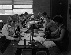 Students seated in biology laboratory with microscopes
