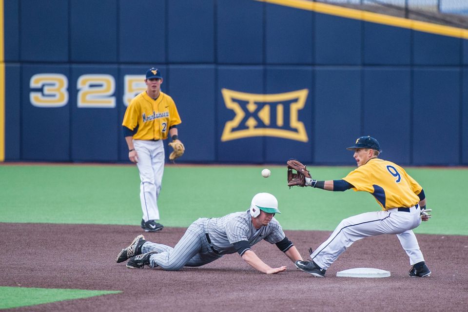 A WVU baseball second baseman attempts to catch a base runner from stealing