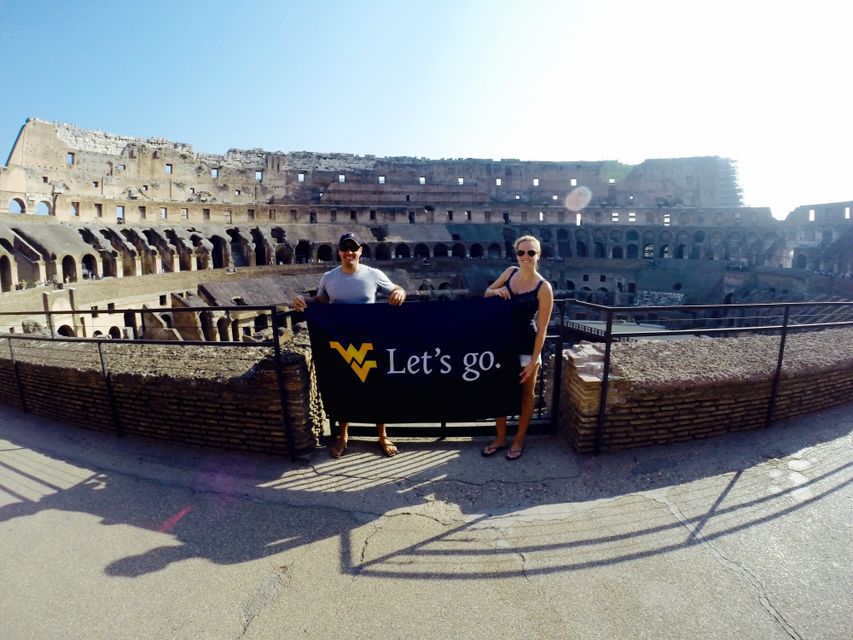 Former WVU students holding up a "Let's go" flag in Italy