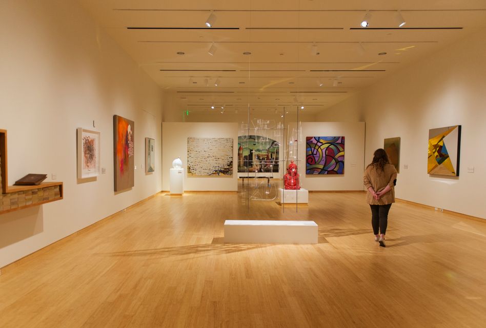 A woman views some of the art in a gallery at the Art Museum