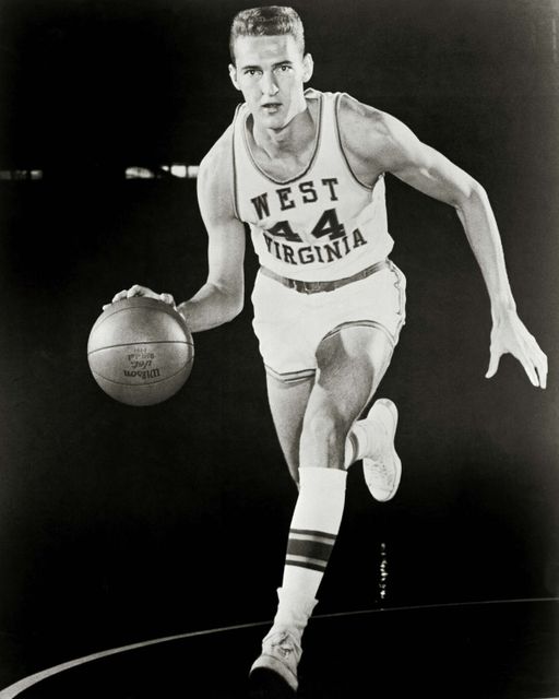 A posed, black-and-white photo of Jerry West dribbling a basketball