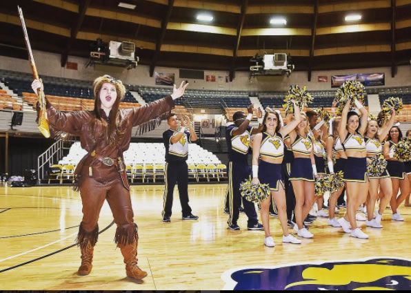 Mountaineer mascot and cheerleaders on a basketball court
