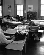 Students working at tables and typewriters