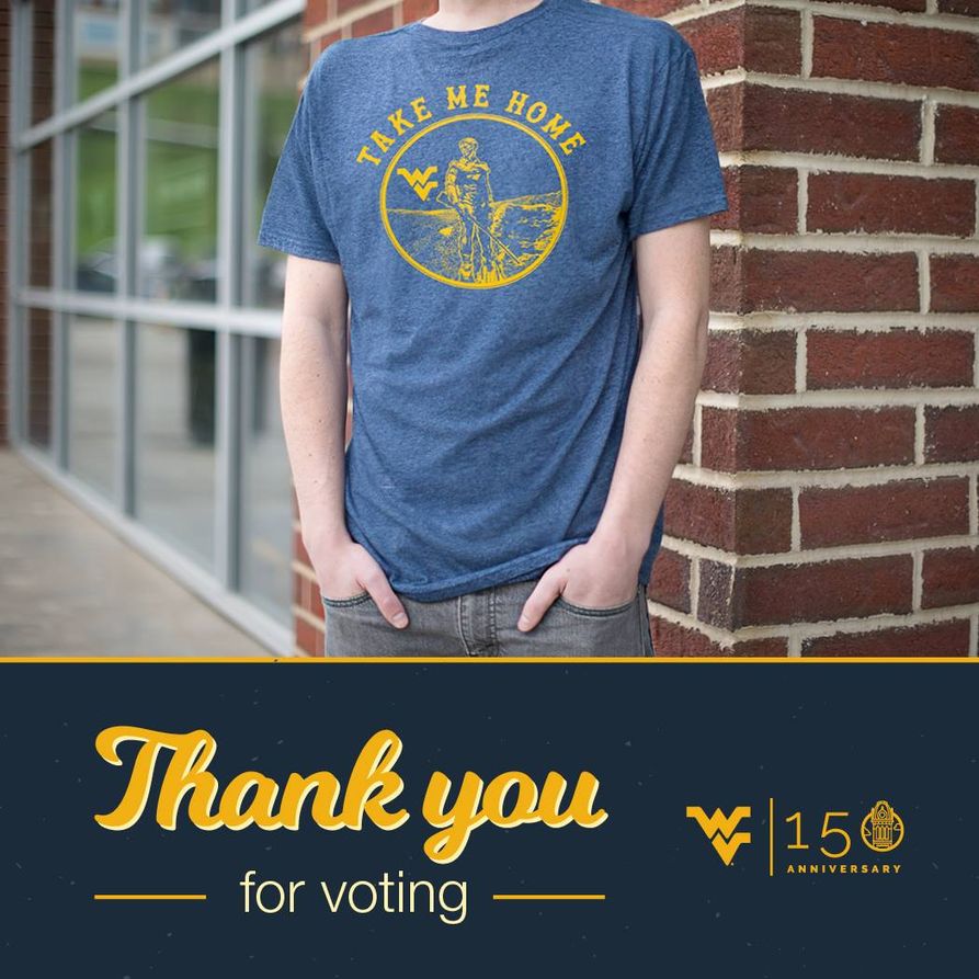 Student wearing the winning shirt. The winning shirt is blue with a gold emblem on the front containing the Mountaineer and the Flying WV. Around the emblem are the words "Take Me Home". Thank you for voting.