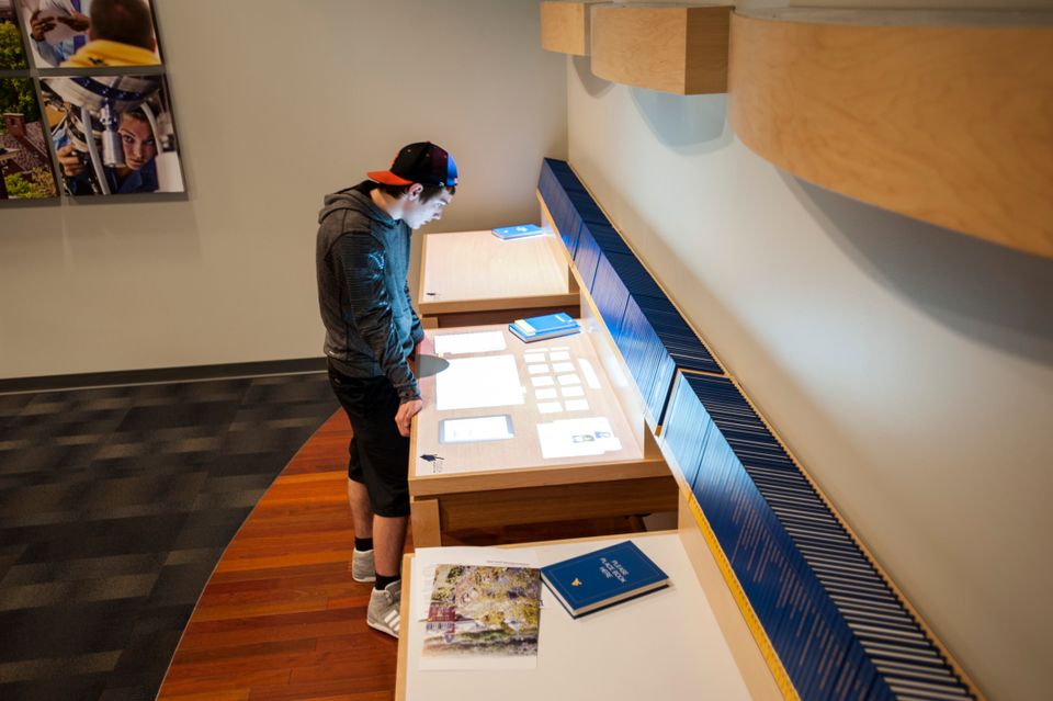 A prospective student looking at one of the interactive displays in the Visitors Center