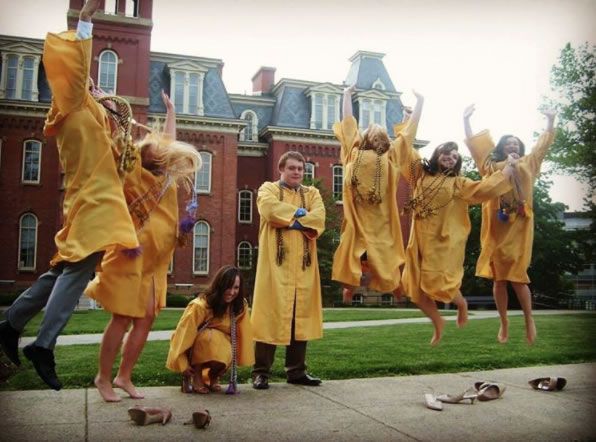 Graduates jumping in front of Woodburn Hall