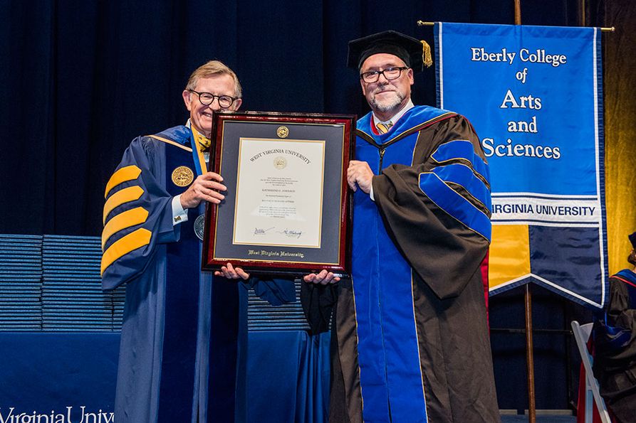WVU officials hold Johnson's framed honorary degree