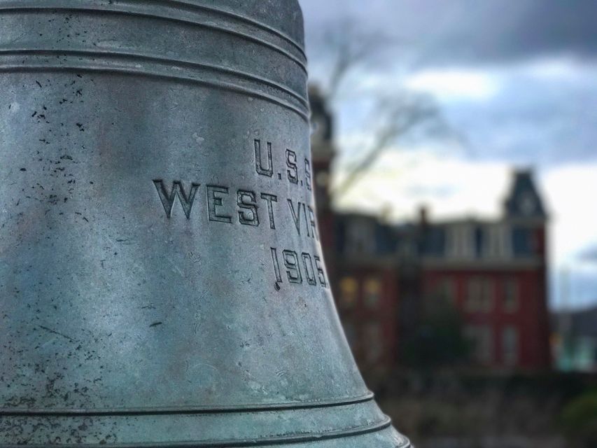 The bell of the U.S.S. West Virginia with Woodburn Hall in the background